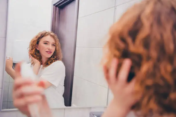 "Curly-haired woman showing off bouncy curls, highlighting the advantages and disadvantages of curly hair such as volume and frizz control."